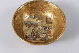 A JAPANESE SATSUMA BOWL, richly gilt decorated, painted to the centre with seated figures. 12.5cms