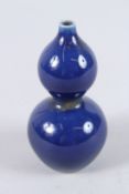 A CHINESE PORCELAIN BLUE GROUND MINIATURE GOURD SHAPE VASE. 11cms high.