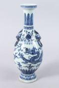 A CHINESE PORCELAIN BLUE AND WHITE BOTTLE VASE, painted with a dragon, with mask handles. 33cms