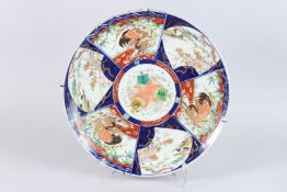 A LARGE JAPANESE IMARI PORCELAIN CHARGER, painted with alternating panels of river landscapes and