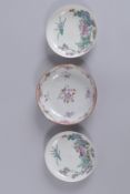 A PAIR OF 19TH CENTURY FAMILLE ROSE PORCELAIN SAUCERS, together with another single saucer, (3).