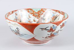 A KUTANI CIRCULAR PORCELAIN BOWL with figures and panels of flowers and motifs. 13ins diameter.