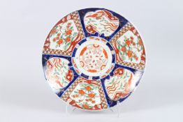 A LARGE JAPANESE IMARI PORCELAIN CHARGER, painted with panels of flowers. 46cms diameter.
