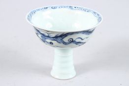 A CHINESE BLUE AND WHITE STEM CUP decorated with dragons. 4.5ins diameter.