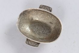 A SMALL TIBETAN TWO HANDLED WHITE METAL OVAL BOWL. 5.5ins long.