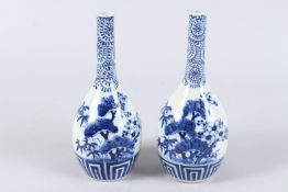 A PAIR OF JAPANESE BLUE AND WHITE PORCELAIN BOTTLE JARS, painted with prunus trees. 21cms high.