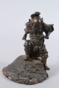 A 19TH CENTURY JAPANESE CAST BRONZE FIGURE OF A SAMURAI, standing on a naturalistic wood base. 20cms