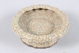 A CHINESE CRACKLE GLAZE POTTERY BRUSH WASHER of shaped form. 14cms diameter.