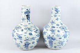 A LARGE PAIR OF CHINESE BLUE AND WHITE BOTTLE VASES with straight necks. 24ins high.