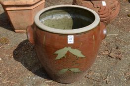 A glazed twin handled terracotta plant pot.