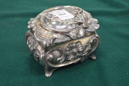 A silver plated ornate casket with hinged cover.