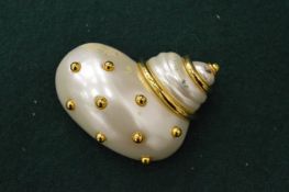 A Kenneth Lane shell shaped brooch.