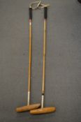 Two polo mallets.