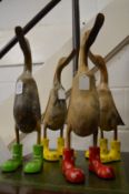 A set of four novelty wooden ducks with colourful feet.