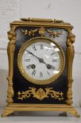 An ormolu and ebonised mantel clock.
