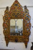 An ornate Eastern carved wood and polychrome decorated wall mirror.