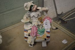 An amusing Continental porcelain box and cover modelled as a colourful musician seated on a drum
