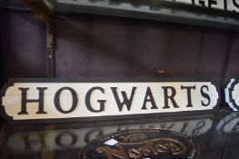 A novelty carved wood and painted sign 'Hogwarts'.