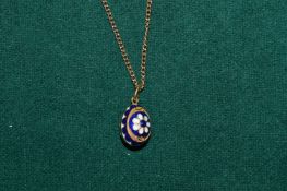 Yellow metal and enamel egg shaped pendant and chain.