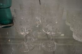 A set of eight engraved glass wine glasses.