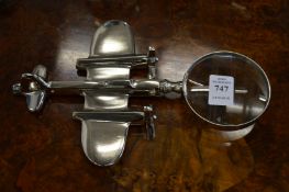 A magnifying glass, the handle modelled as an aeroplane.