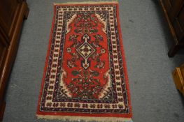 A small Persian design rug, 132cm x 69cm.