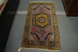 A small Persian rug, purple ground with geometric decoration, 155cm x 86cm.