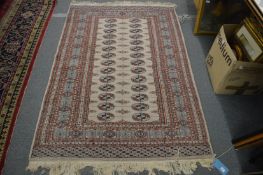A modern Bokhara style rug, beige ground with two rows of 14 gulls, 190cm x 126cm.