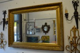 A large gilt framed rectangular mirror.
