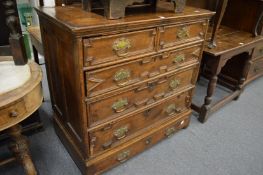 An 18th century oak chest on stand with two short and three long drawers with panelled decoration on