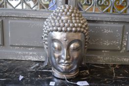 A silvered resin model of a Buddha's head.