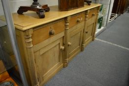Pine dresser base with three drawers and three cupboard doors.