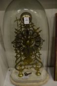 A good brass skeleton clock under a glass dome.