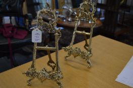 A pair of small ornate brass easels.