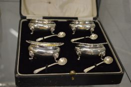 A cased set of four silver salts with spoons.