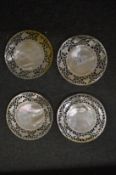 A set of four mother of pearl circular dishes with pierced borders.