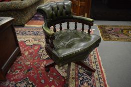 A green button leather upholstered mahogany framed swivel armchair.