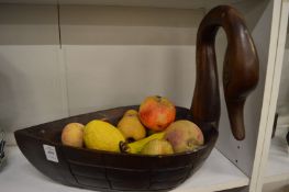 A swan shaped carved wood bowl containing a quantity of realistic painted alabaster fruit.