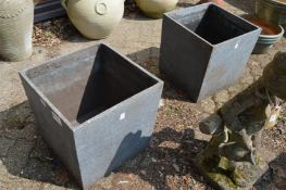 A pair of faux granite style square shaped planters.