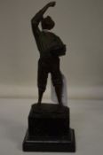 A small bronze of a boy holding a hat on a marble base.