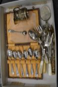 A box set of plated teaspoons and other items.