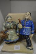 An amusing pottery group of a man and a women.