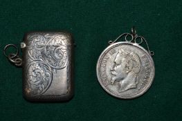 An engraved silver vesta case and a mounted coin pendant.