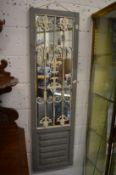 A pair of decorative garden mirrors with distressed paint finish and wrought iron decoration.