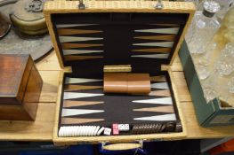 A wicker travelling backgammon set.