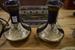 A pair of satsuma vases painted with panels of women and children.