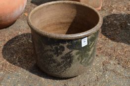 A small glazed terracotta plant pot.
