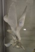 Lladro figure of a bird with its wings outswept.