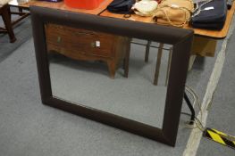 A wall mirror with faux leather frame.