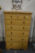 A tall pine chest of drawers.